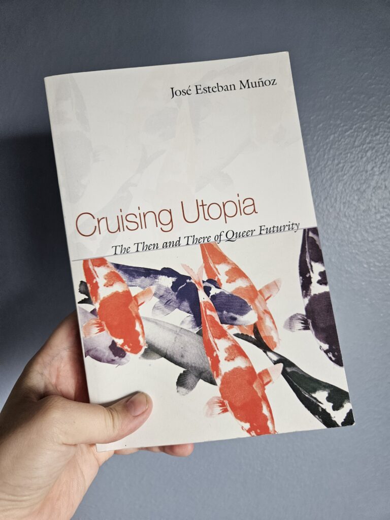 Hand holding book: Cruising Utopia